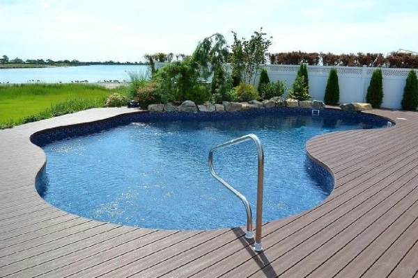 Piso deck WPC antideslizante instalado en borde de piscina moderna